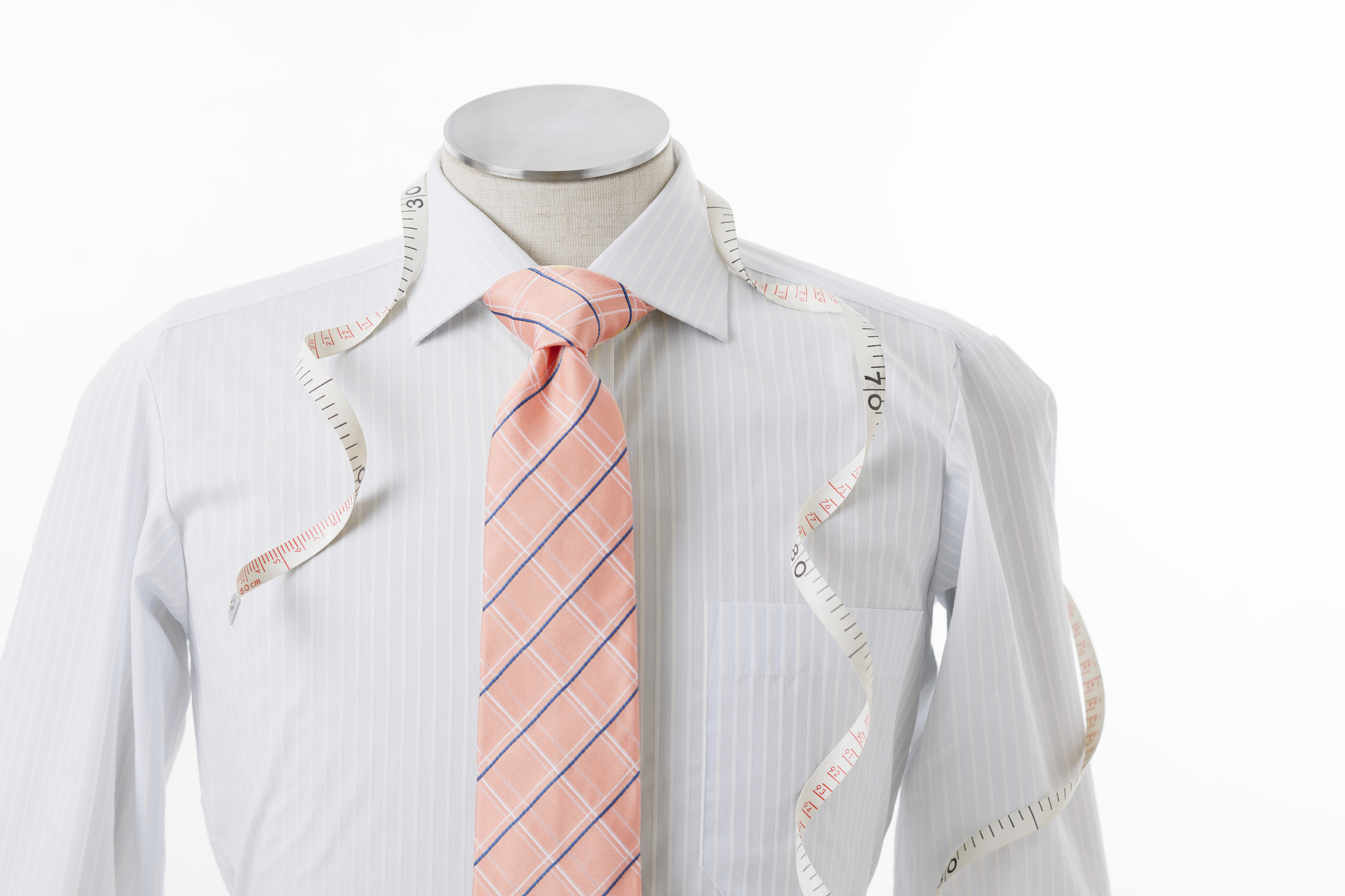 ストライプの白いシャツに細いネイビーと白のチェック柄のサーモンピンクのネクタイを着たマネキン