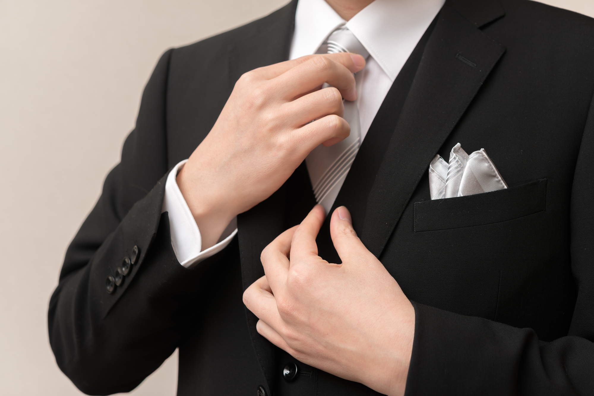 ネクタイを整える礼服を着た男性